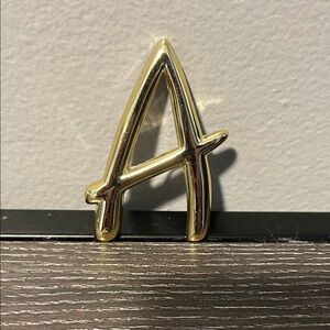 Golden “A” brooch